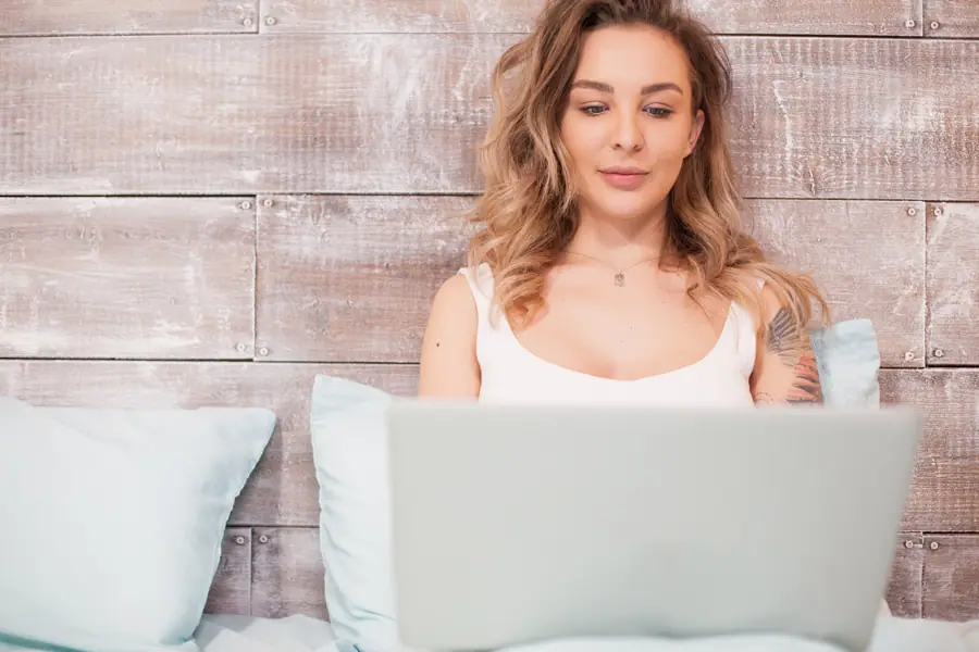 Femme souriante devant un ordinateur portable, annonce sexy à Saguenay